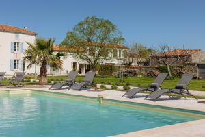 a group of chairs sitting next to a swimming pool at La Belle Parenthèse à la Rochelle in Vergné