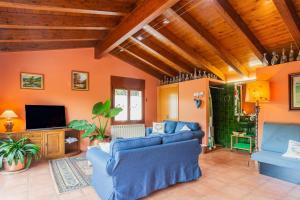 a living room with blue couches and a tv at Ca la Montse in Viladrau
