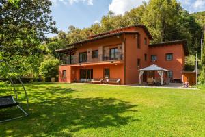 an orange house with a lawn in front of it at Ca la Montse in Viladrau