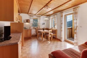 a kitchen and dining room with a table and a dining room at New Teindlhof in Curon Venosta