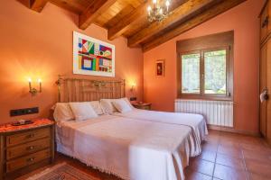a bedroom with a large bed with orange walls at Ca la Montse in Viladrau +29 photos