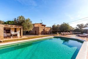 a swimming pool in front of a house at Es Figueral in Campos