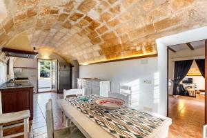 a kitchen and dining room with a stone ceiling at Es Figueral in Campos