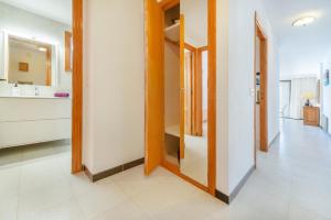 a kitchen with white walls and a hallway with a mirror at Puerto Rico Apt. Port de Sóller in Port de Soller +16 photos