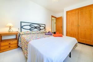 a bedroom with a large bed and a wooden cabinet at Puerto Rico Apt. Port de Sóller in Port de Soller