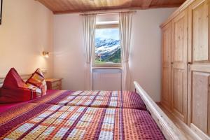 a bedroom with a bed and a window with a snow covered mountain at New Teindlhof in Curon Venosta