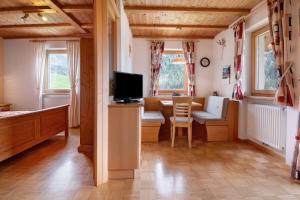 a living room with a television and a dining room at New Teindlhof in Curon Venosta