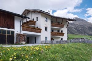 a building with a field of flowers in front of it at New Teindlhof in Curon Venosta