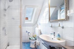 a bathroom with a sink and a toilet and a shower at Ferienwohnung Apfelkorb in Jork +27 photos