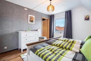 a bedroom with a bed and a dresser and a window at Ferienwohnung Apfelkorb in Jork