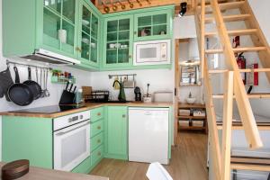 a kitchen with green cabinets and a ladder at Casa Valada My Land in Valada