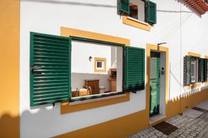 a building with green shutters and a room at Casa Valada My Land in Valada