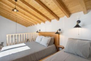 two beds in a bedroom with wooden ceilings at Casa Valada My Land in Valada +13 photos
