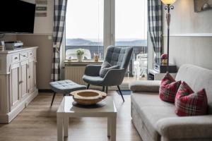 a living room with a couch and two chairs and a table at Harzperle Wohnung Nr 6 in Braunlage