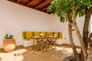 a dining room with a table and a tree at Finca Remedios in Los Valles