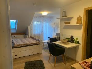 a bedroom with a bed and a desk and a table at Haus Zum Haiden in Bodman-Ludwigshafen