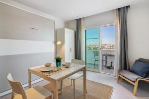 a dining room with a table and chairs and a window at Bay View Albufeira in Albufeira