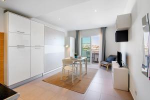 a kitchen and living room with a table and chairs at Bay View Albufeira in Albufeira