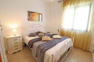 a bedroom with a white bed and a window at Casa Caterina a Otranto in Otranto