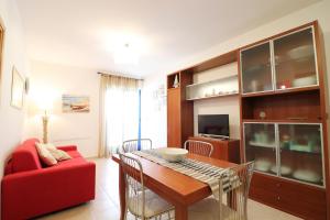 a living room with a table and a red couch at Casa Caterina a Otranto in Otranto