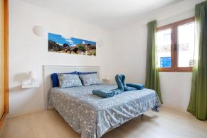 a bedroom with a bed with a blue comforter at Casita Martina in Punta Mujeres