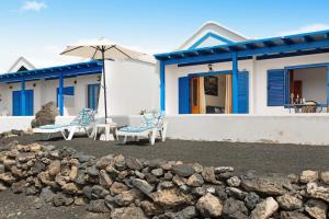a house with two chairs and an umbrella at Casita Martina in Punta Mujeres