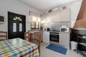 a kitchen with white cabinets and a table with a table cloth at Casa Mourelo Alojamento Local in Ponte da Barca +25 photos