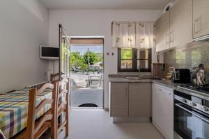 a kitchen with white cabinets and a view of a patio at Casa Mourelo Alojamento Local in Ponte da Barca