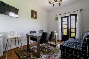 a living room with a table and chairs and a couch at Casa Mourelo Alojamento Local in Ponte da Barca