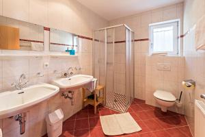 a bathroom with two sinks and a shower and a toilet at Ferienwohnung Jakob in Schwendau +18 photos