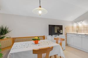 a kitchen with a table with a vase of flowers on it at Ferienwohnung Wennesz 2 in Chieming +18 photos