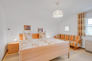 a bedroom with a bed and a couch at Ferienwohnung Wennesz 2 in Chieming