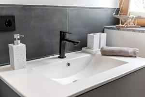 a bathroom sink with a faucet and two towels at Rosenquarz in Überlingen +20 photos