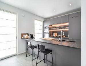 a kitchen with three bar stools at a counter at Villa Angelina in Lazise