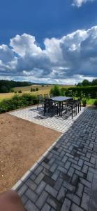 a picnic table and chairs on a brick patio at Haus im Igelweg in Bad Münstereifel