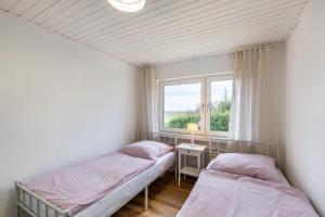two beds in a room with a window at Haus im Igelweg in Bad Münstereifel