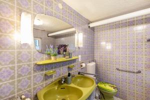 a bathroom with a yellow sink and a mirror at Haus im Igelweg in Bad Münstereifel +22 photos