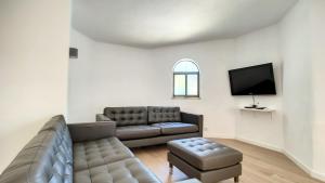 a living room with a couch and a tv at Villa Palmeira Galé Beach in Albufeira