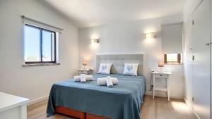 a bedroom with a blue bed with two white pillows at Villa Palmeira Galé Beach in Albufeira +47 photos