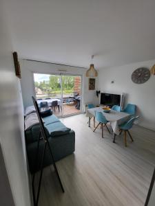 a living room with a couch and a table and chairs at Appartement paisible Richelieu in Chaveignes