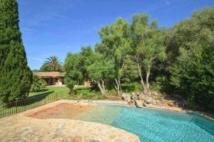 a swimming pool in a yard with trees and a house at Sestadors in La Puebla