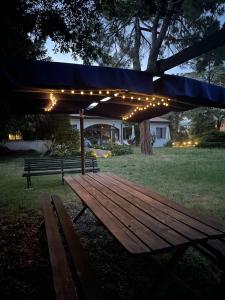 a wooden picnic table under a canopy with lights at Villa Giacinti in Padova