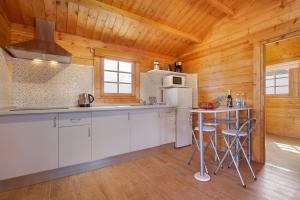 a kitchen with white cabinets and a table and a refrigerator at La Cabañita de Javi in Tuineje