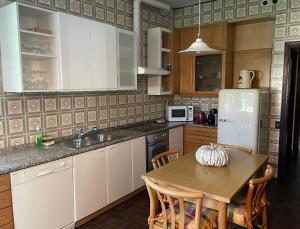 a kitchen with a table and a refrigerator at Villa Giacinti in Padova
