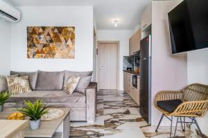 a living room with a couch and a tv at Oceanida Thalia Lyxury Suite in Nikiana