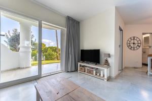 a living room with a tv and a large window at Casa Feliz in Mijas