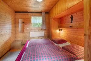 a bedroom with two beds in a wooden cabin at Haus 7 Bernau in Bernau im Schwarzwald