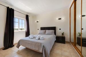 a bedroom with a bed with towels on it at Villa Ramos in Lagos