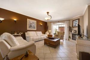 a living room with white couches and a tv at Villa Ramos in Lagos
