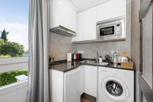 a kitchen with a washing machine and a microwave at Manuela's whim in Málaga +12 photos